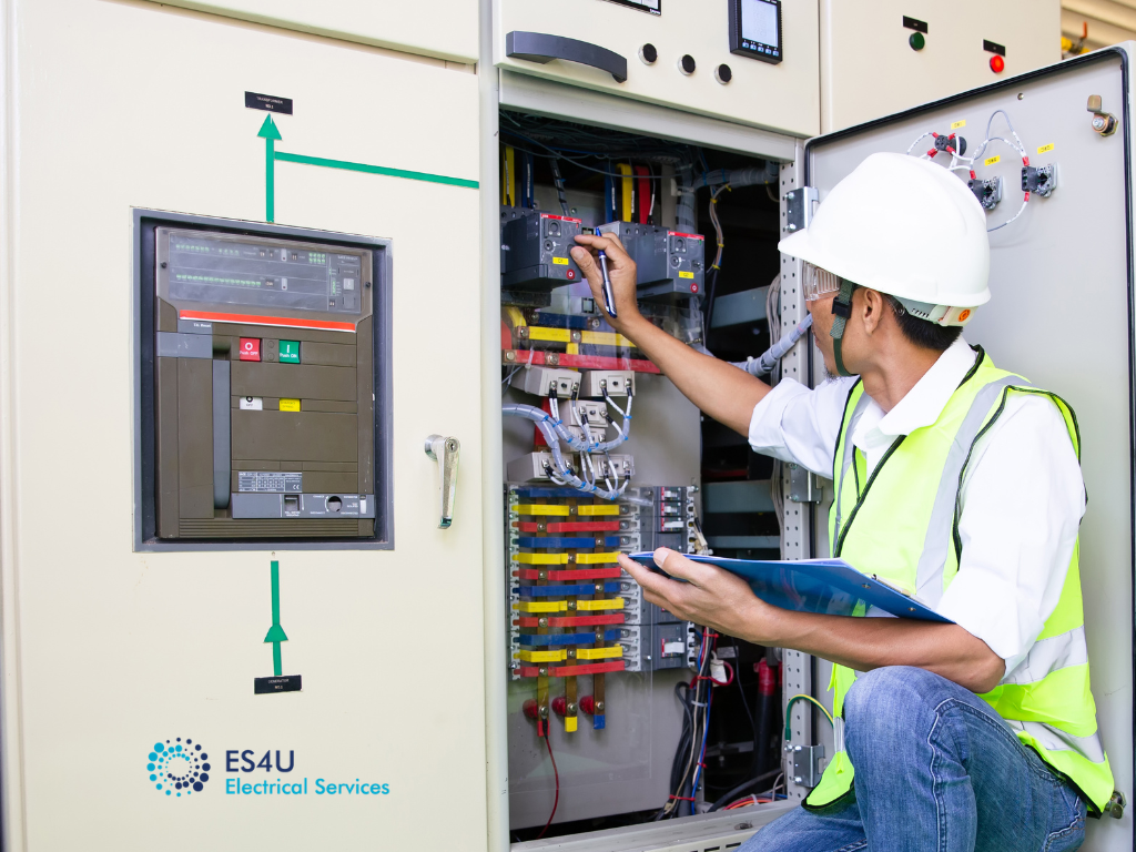 Electrician inspecting electrical connections on industrial manufacturing machinery